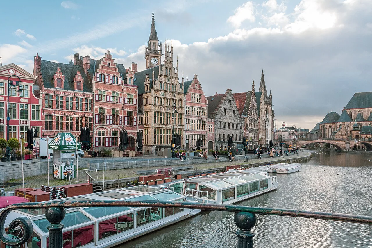 Tour boats moored below the historic gabled façades of the Graslei in Ghent.