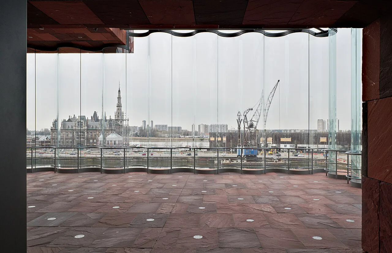 Antwerp's docks seen through the curved glass walls of the MAS museum.