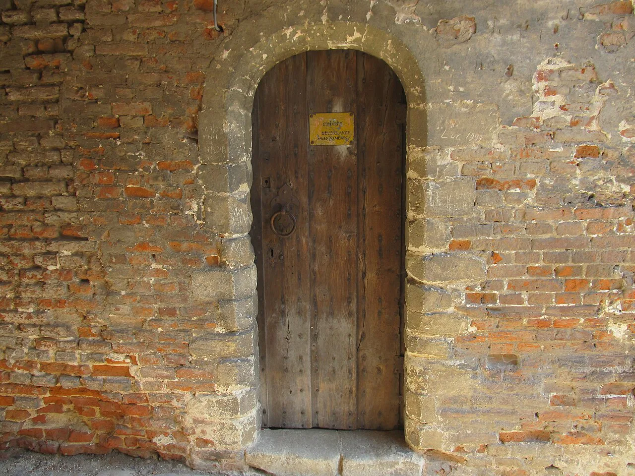 A wooden door set in the brick walls of Beersel Castle.