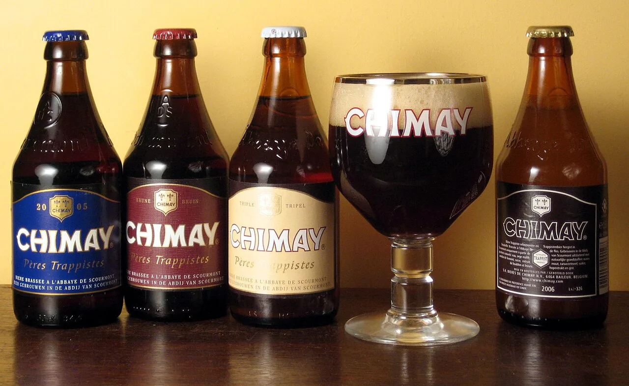 The Chimay Trappist beers lined up with a filled Chimay chalice glass.