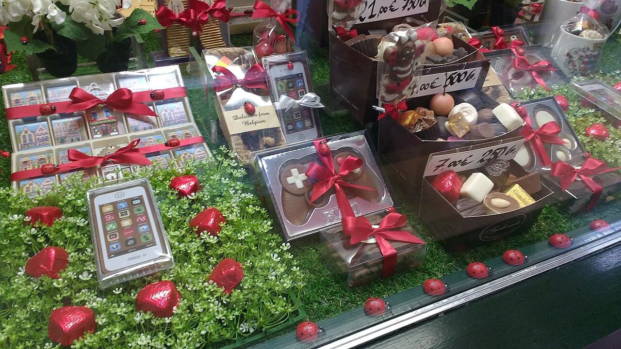 A chocolate shop window in Bruges filled with gift-wrapped boxes of pralines.