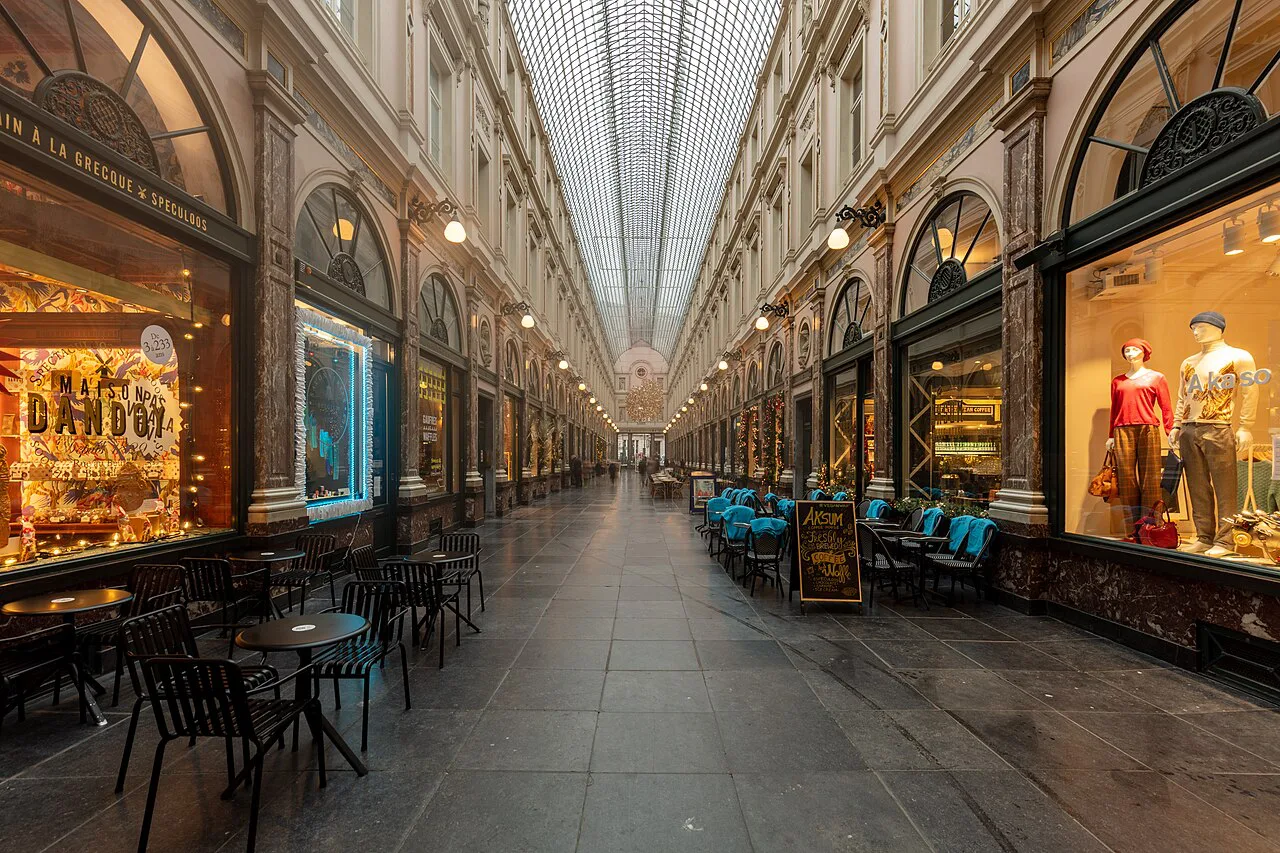 Shop windows and café tables in the Galeries Royales Saint-Hubert shopping arcade in Brussels.