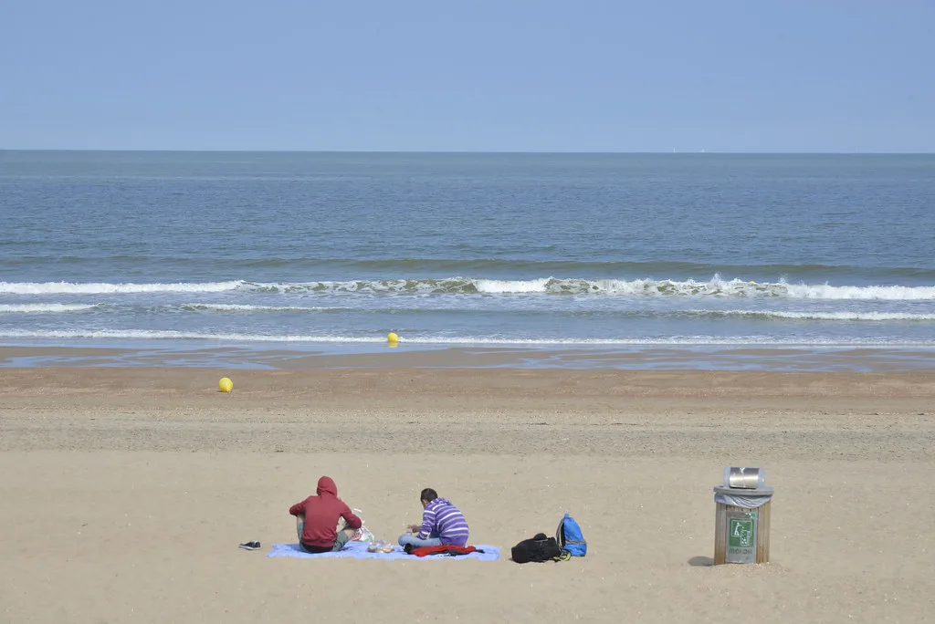 Beachgoers relaxing on the sand at Ostend on a summer morning.