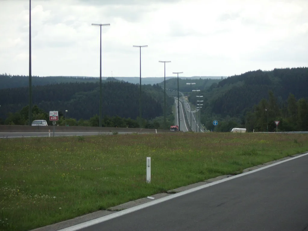 A motorway winding through the wooded hills of the Belgian Ardennes.