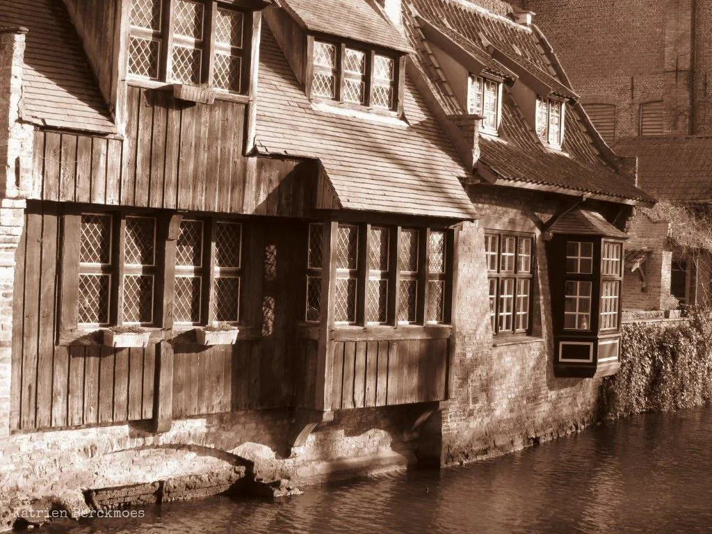 Old brick houses rising straight from a canal in Bruges.