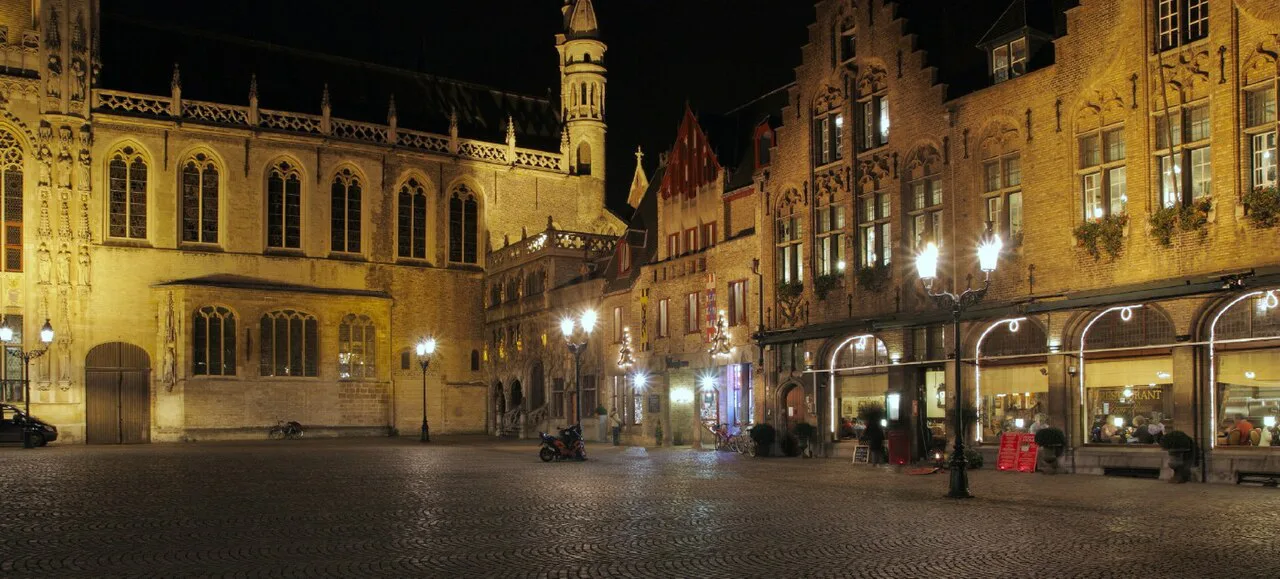 The Burg square in Bruges lit up at night.