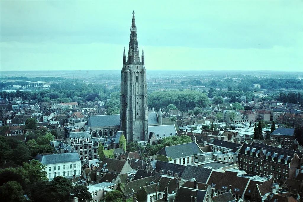 The brick tower of the Church of Our Lady rising above the rooftops of Bruges.