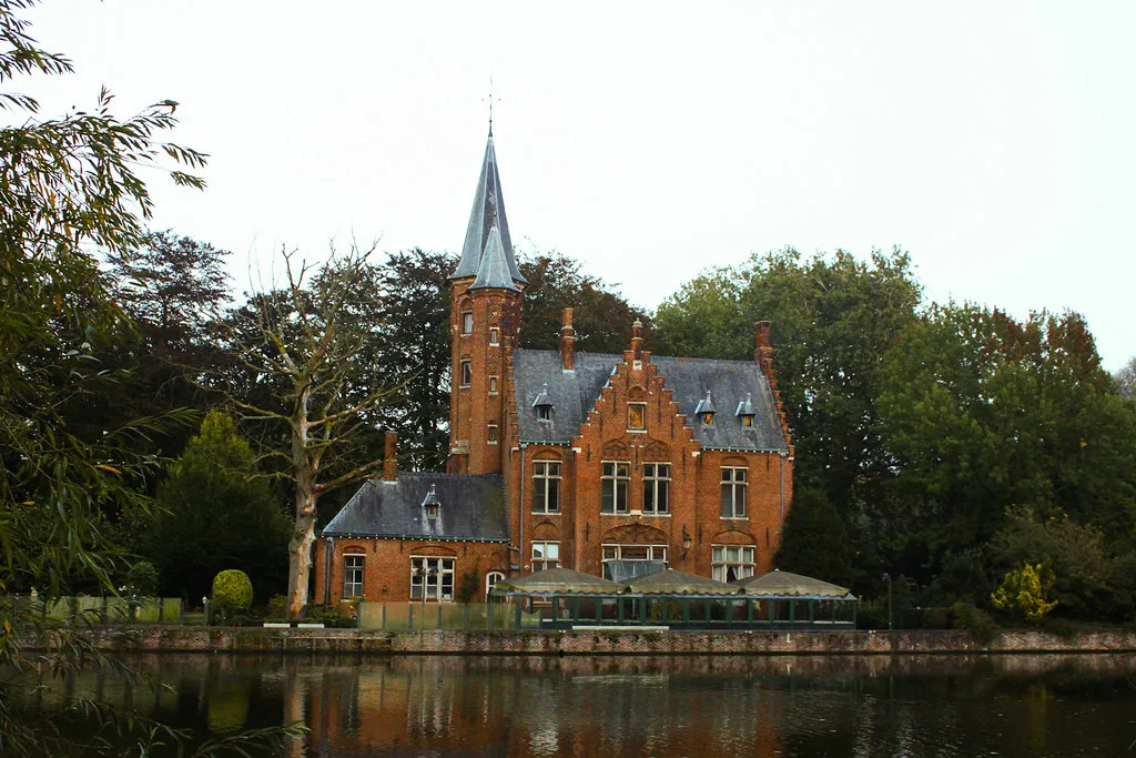 A turreted red-brick mansion beside the Minnewater lake in Bruges.