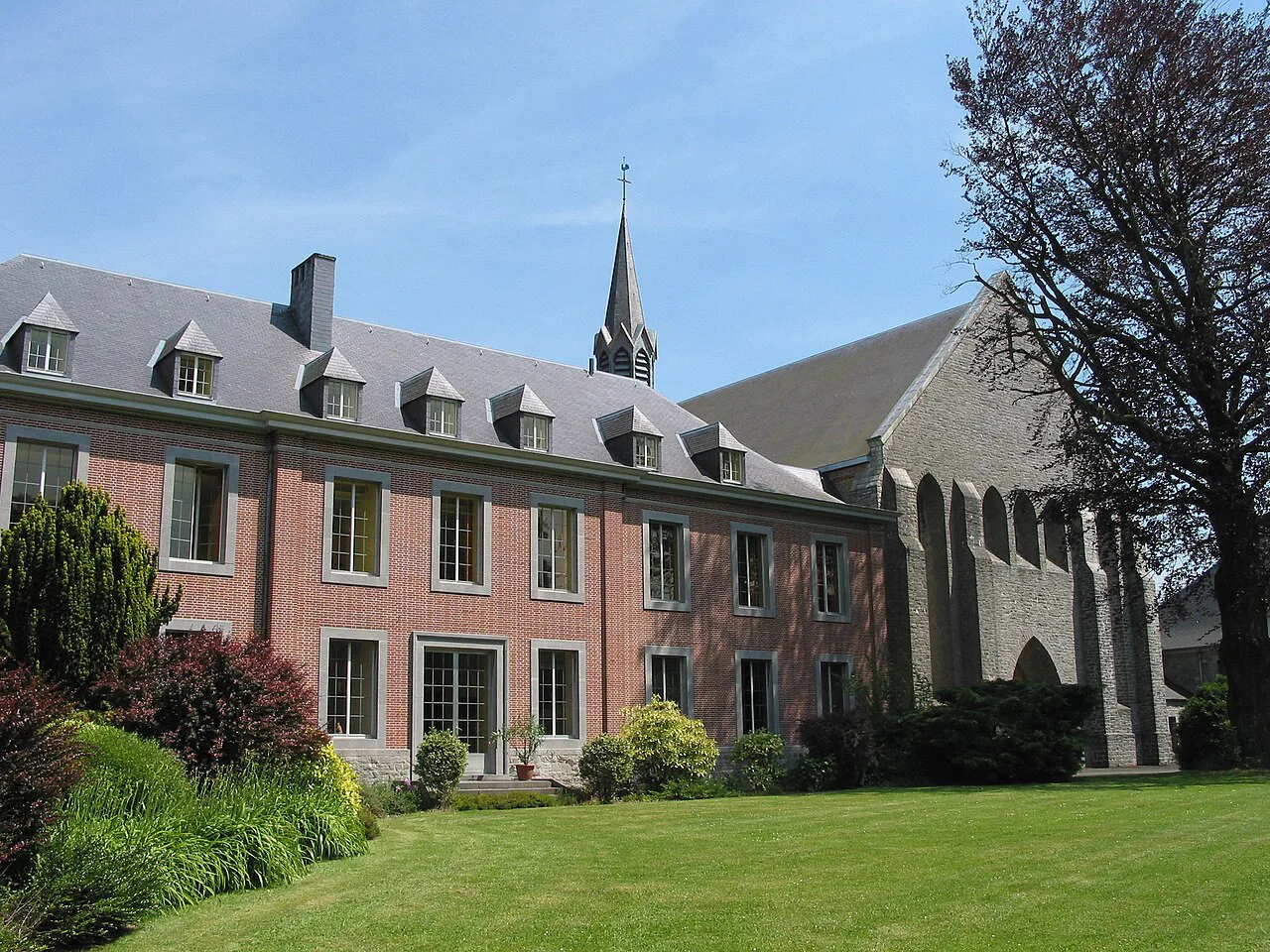A wing of Scourmont Abbey beside its garden near Chimay.