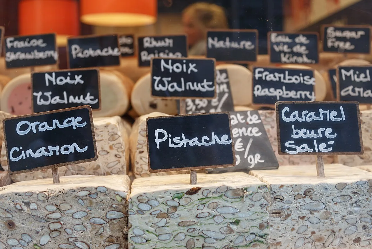 Blocks of Belgian nougat with handwritten flavour labels on sale in a Bruges shop.