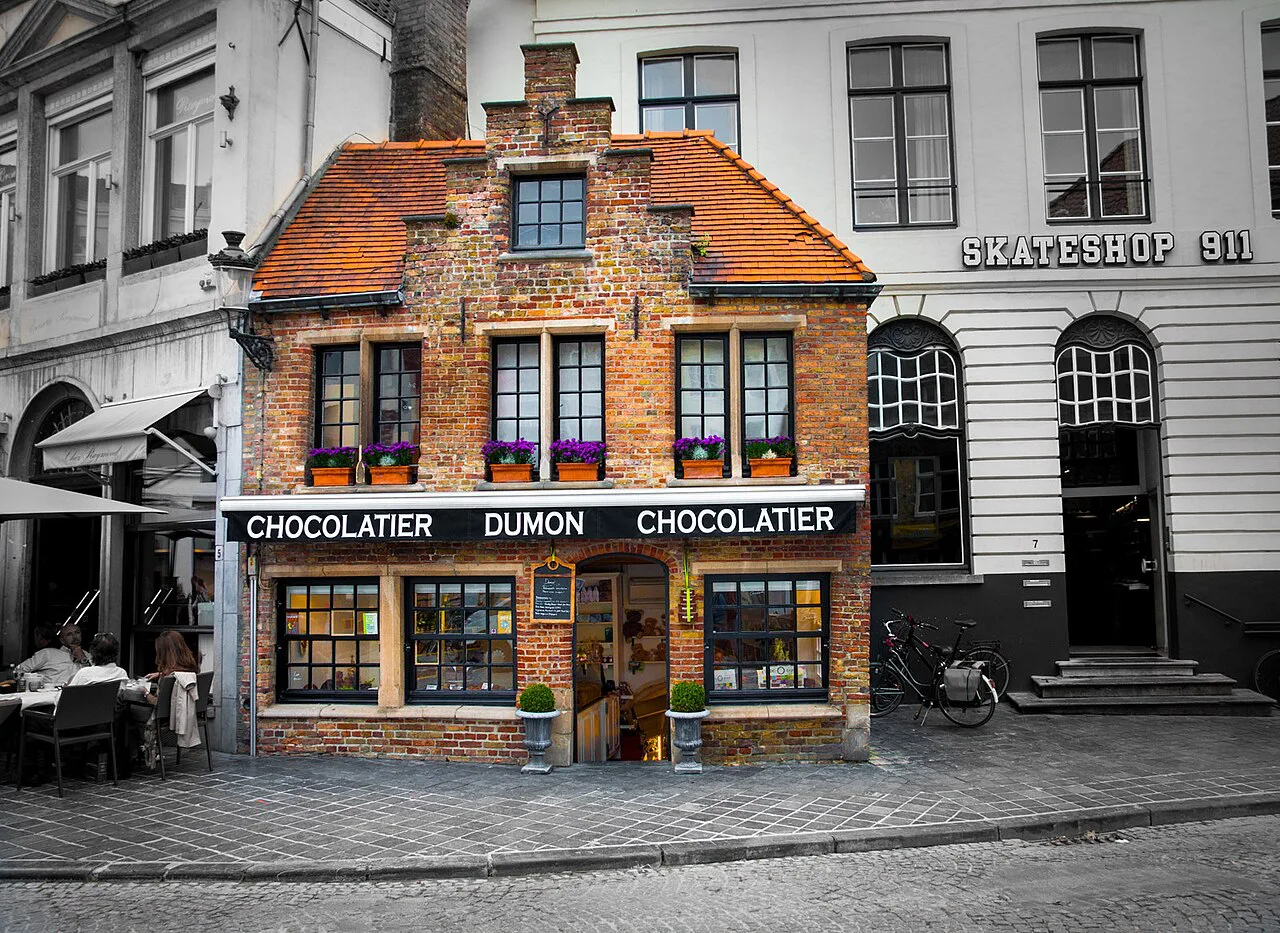 The brick façade of Chocolatier Dumon, a chocolate shop in Bruges.