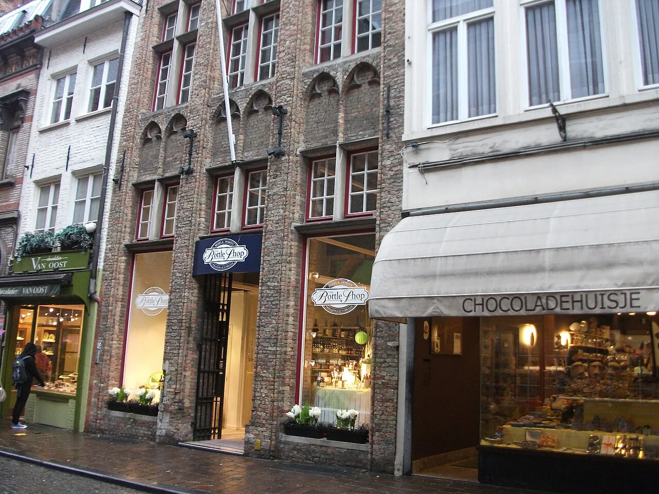 Chocolate shops on Wollestraat in Bruges, including Chocolatier Van Oost and Chocoladehuisje.