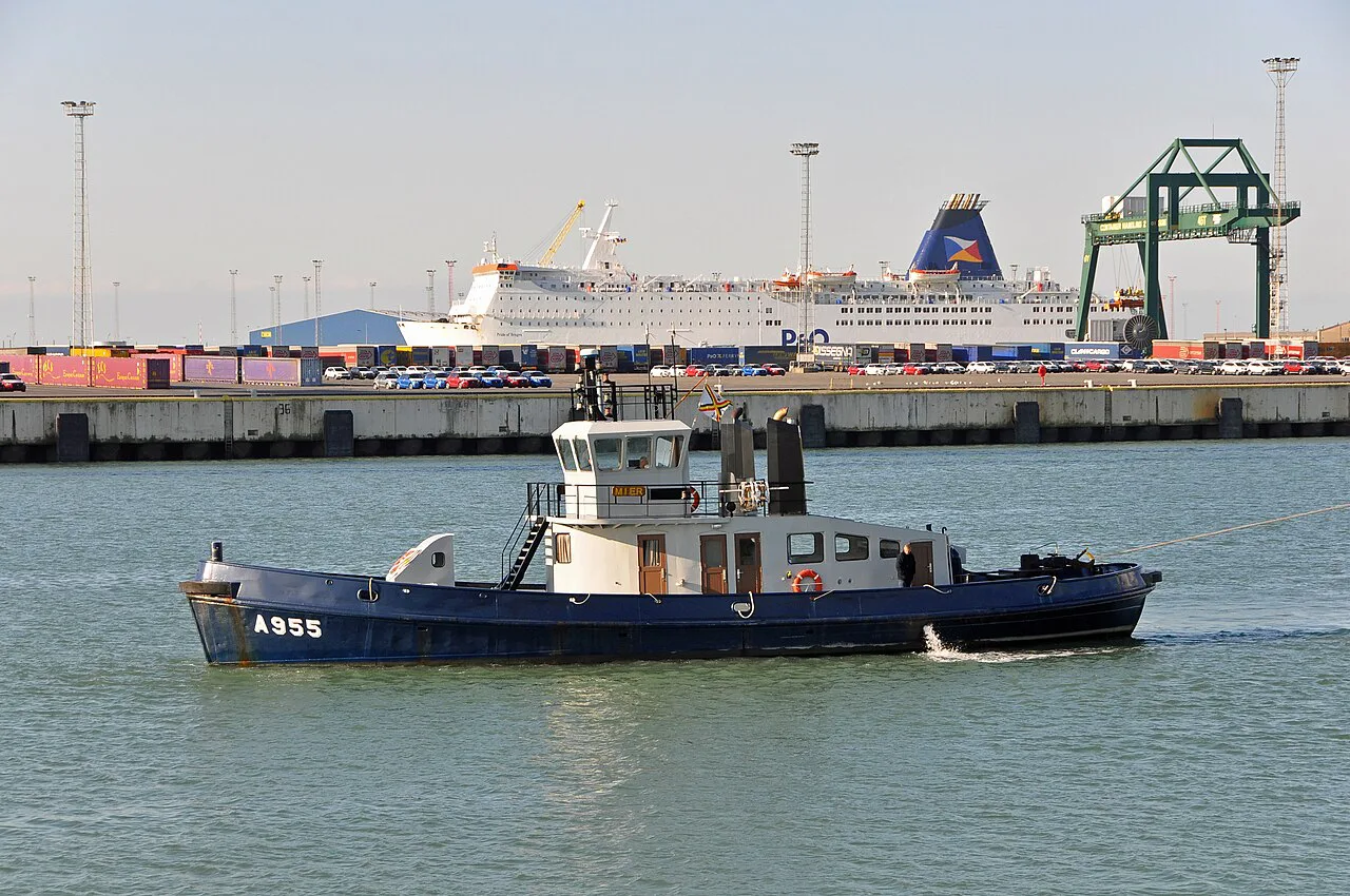 A Belgian navy tug in the port of Zeebrugge, with a P&O ferry in the distance.