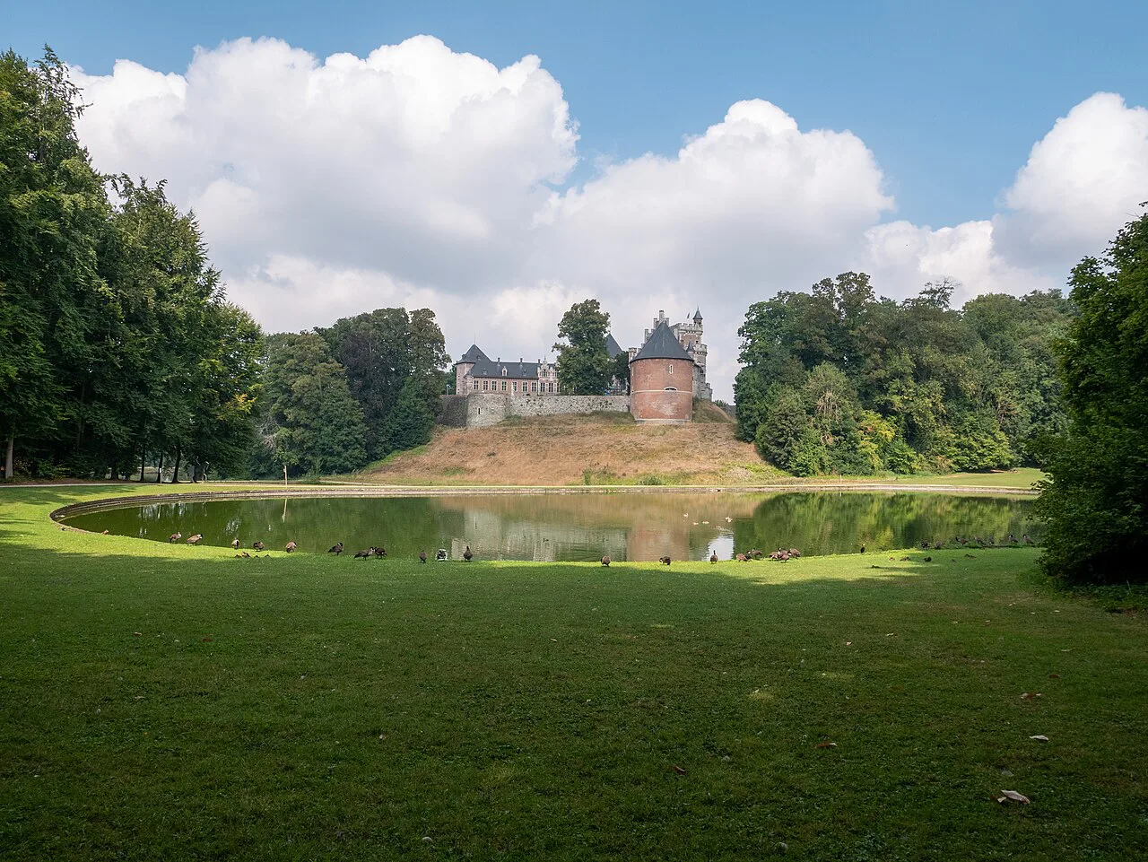 Gaasbeek Castle seen across the pond in its parkland.