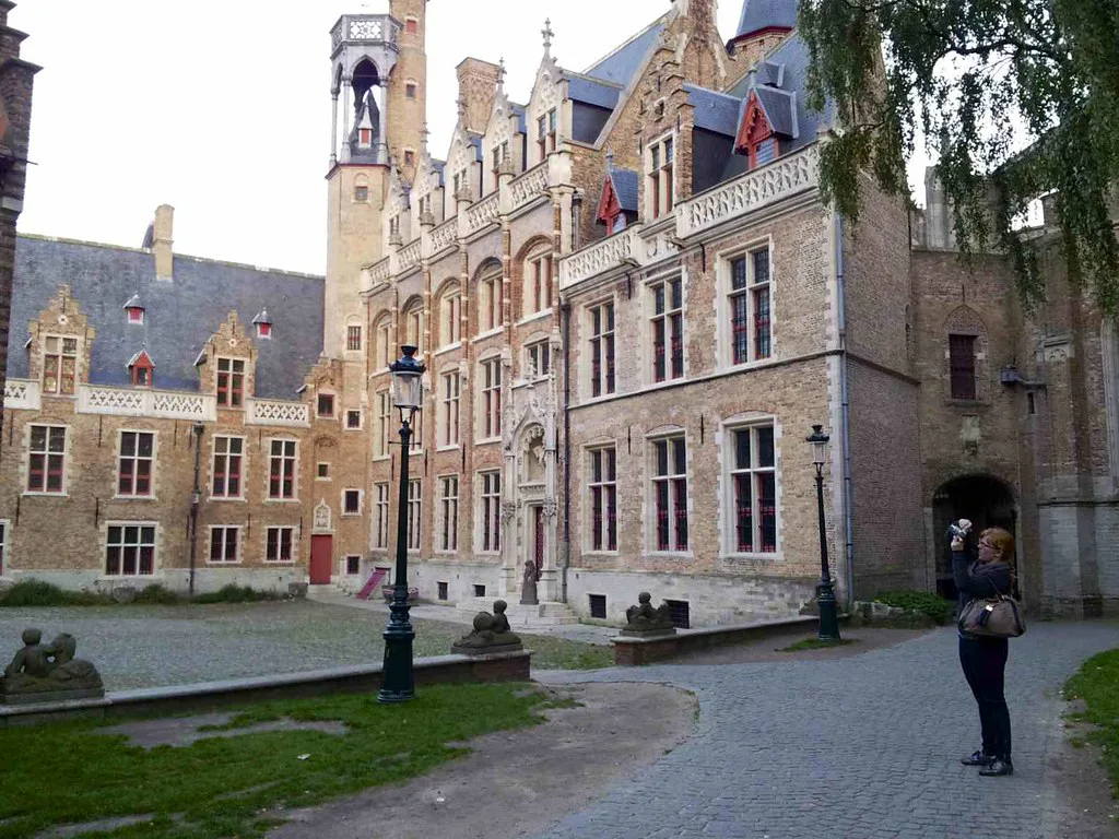 Historic brick buildings around a courtyard in central Bruges.