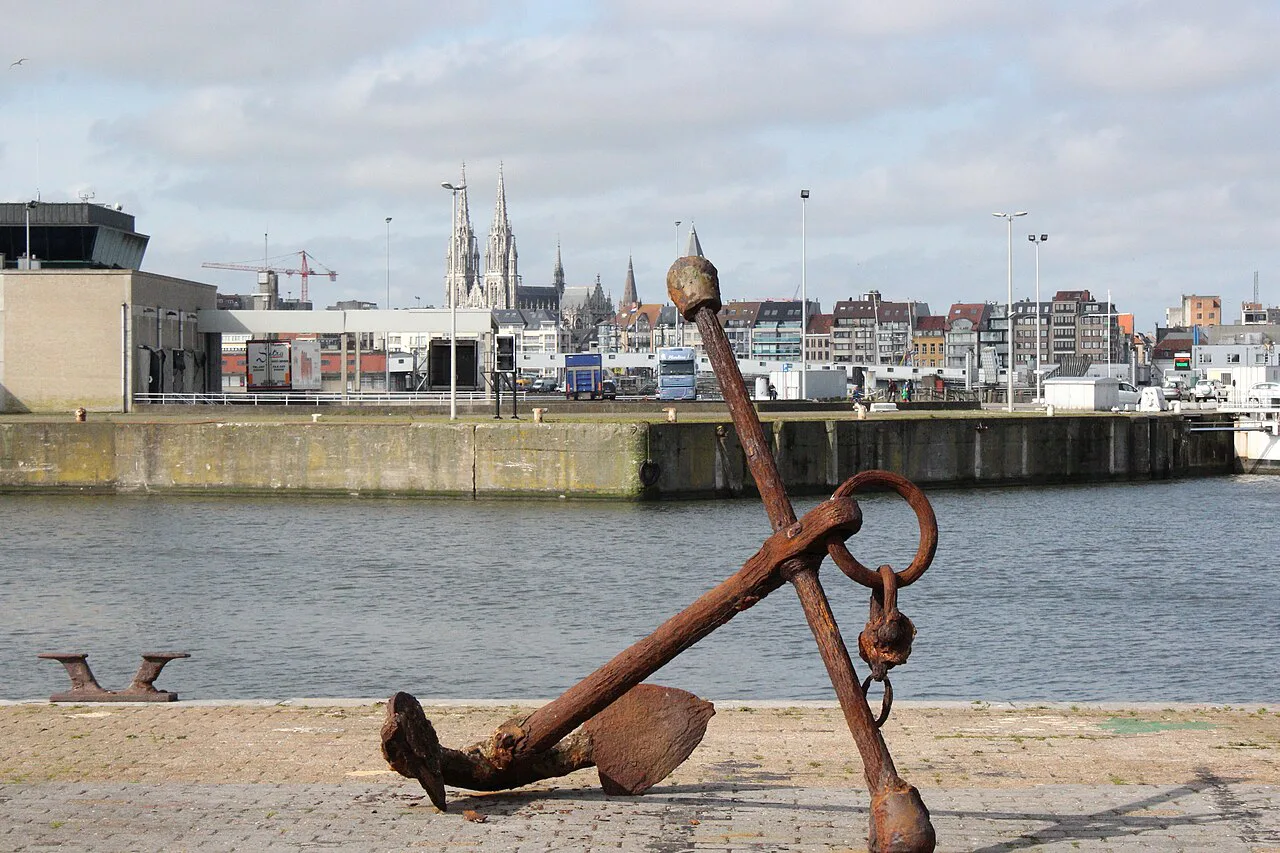 An old anchor on the east bank quay overlooking Ostend harbour and the town, Ostend.