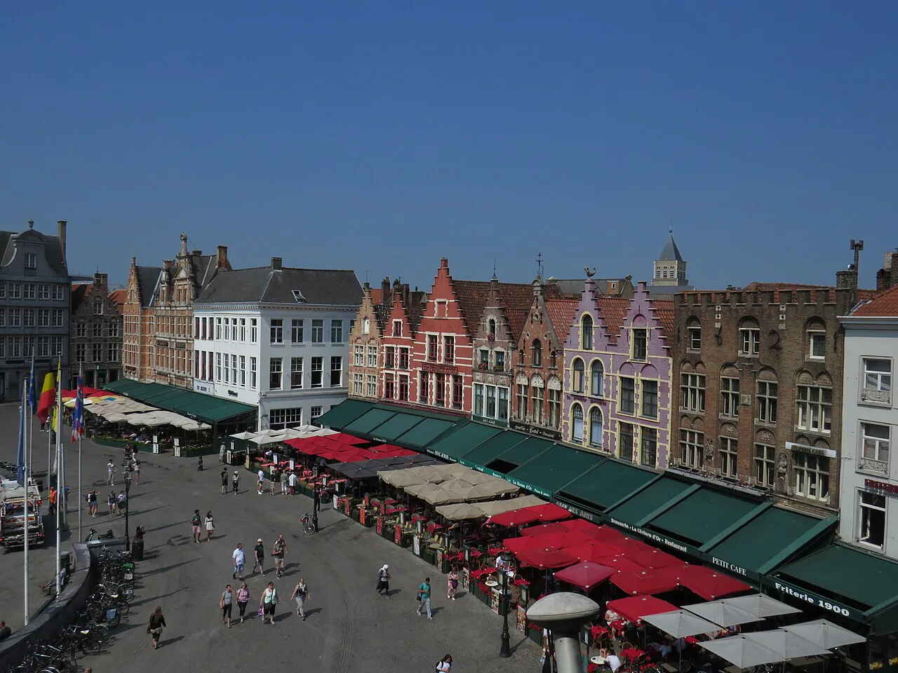 A row of restaurant terraces on a square in Bruges.