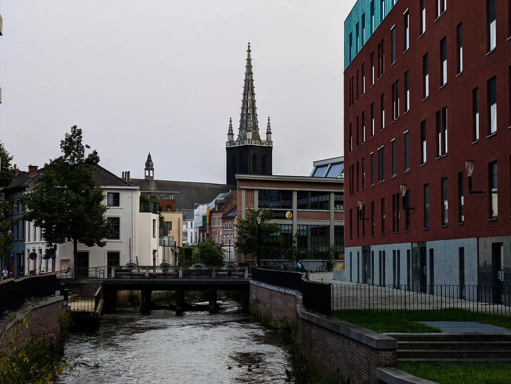 A canal and church spire in central Leuven.