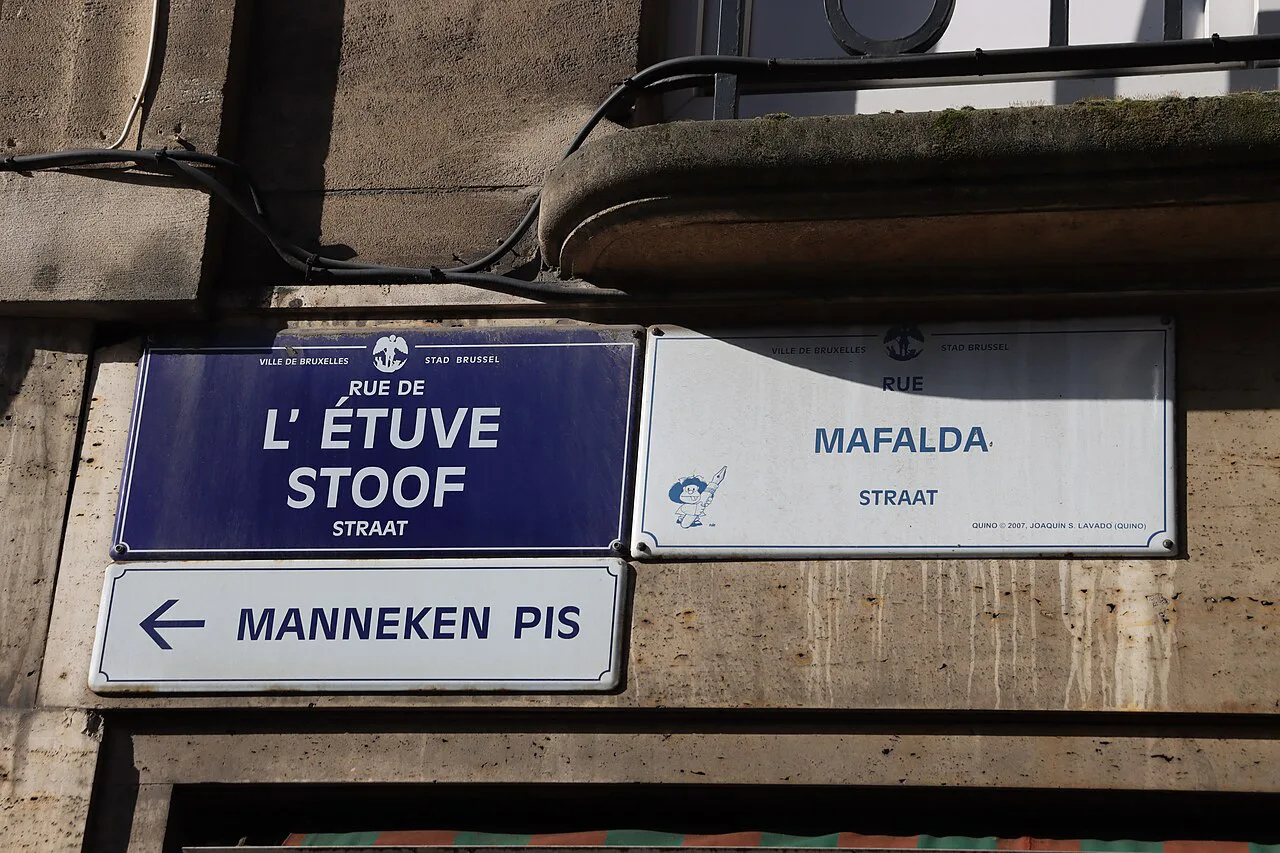 Bilingual French and Dutch street signs in Brussels, with a pointer to Manneken Pis.