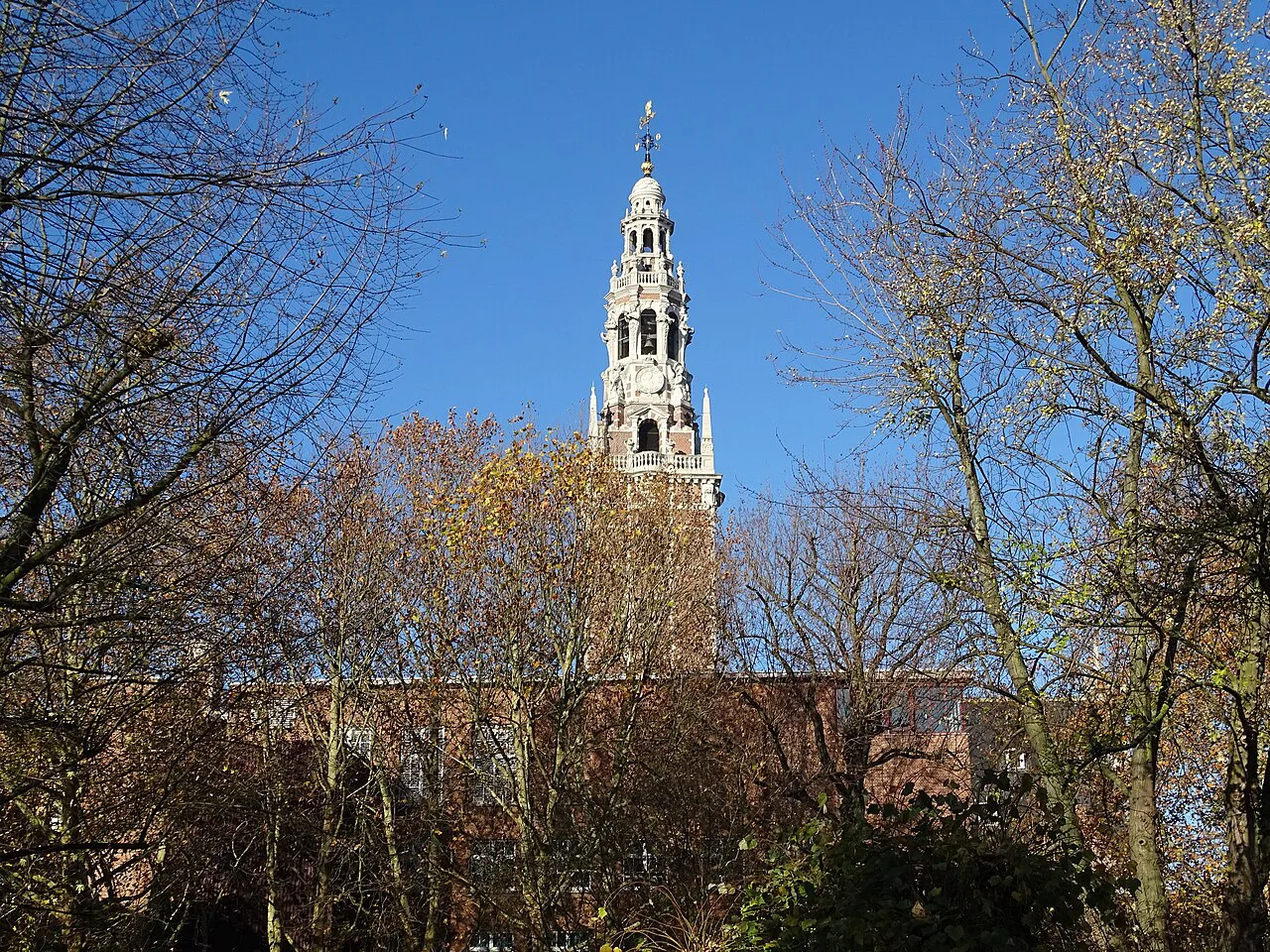The tower of the University Library rising above autumn trees, Leuven.