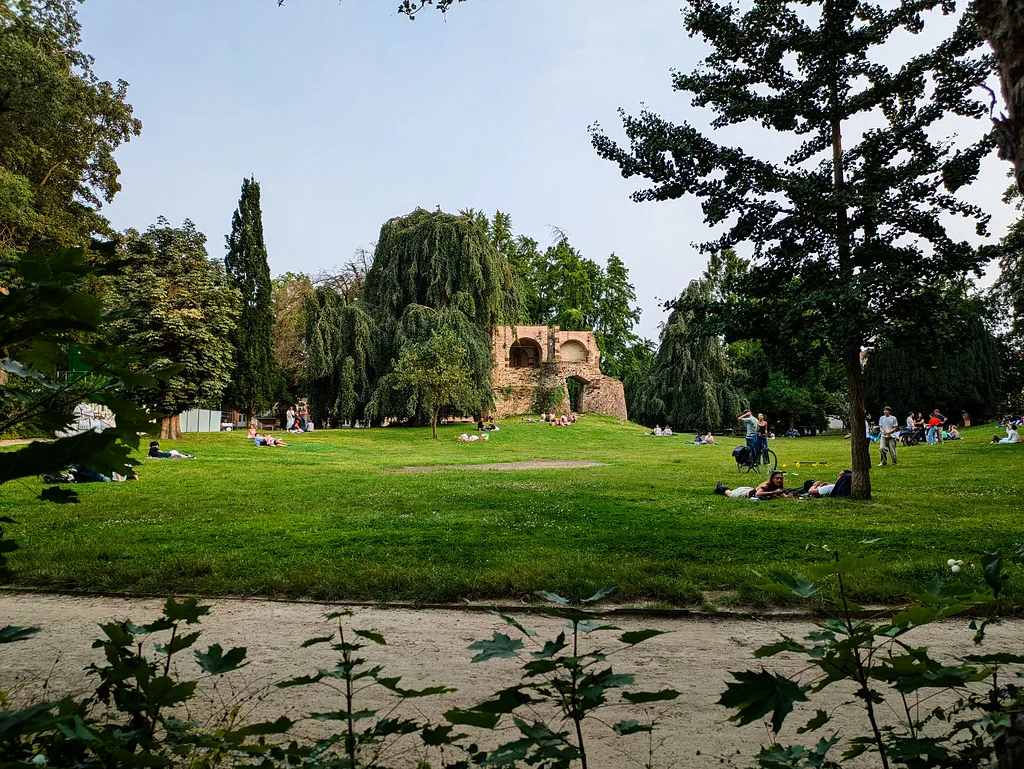 A park in Leuven with a ruined medieval tower among the trees.