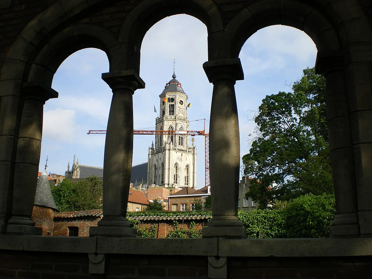 The tower of St Gummarus Church seen through the arches at the Vismarkt, Lier.