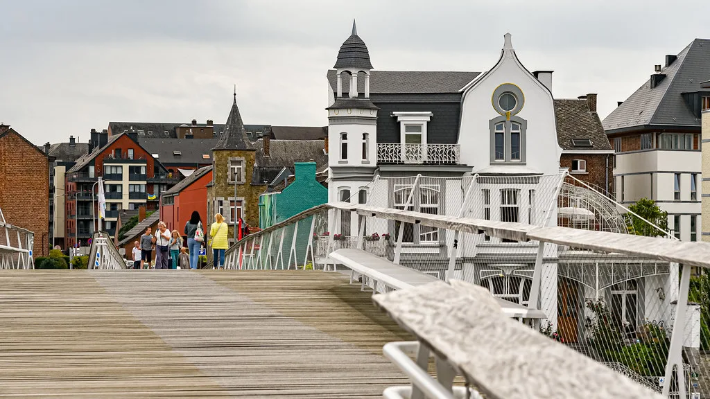 A footbridge leading towards colourful houses in Namur.