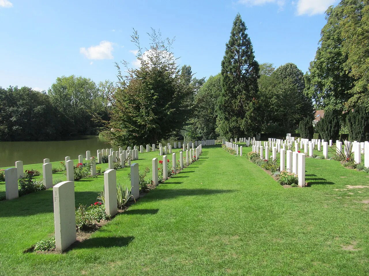 Rows of headstones beside the ramparts moat at Ramparts Cemetery, Ypres.