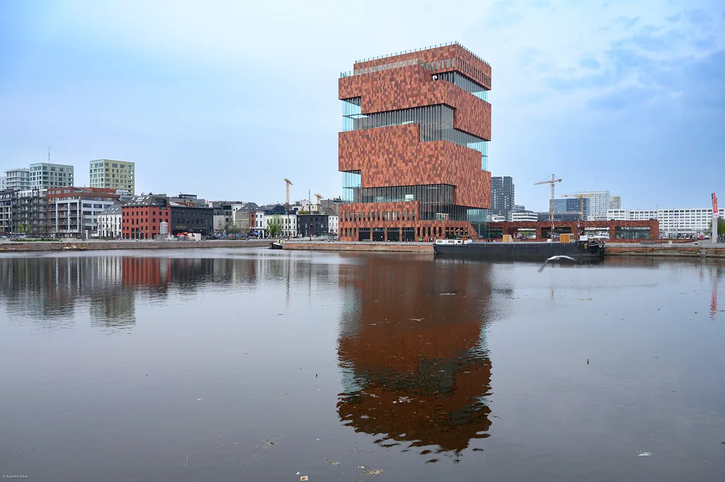 The MAS museum reflected in the water of the Eilandje docks in Antwerp.