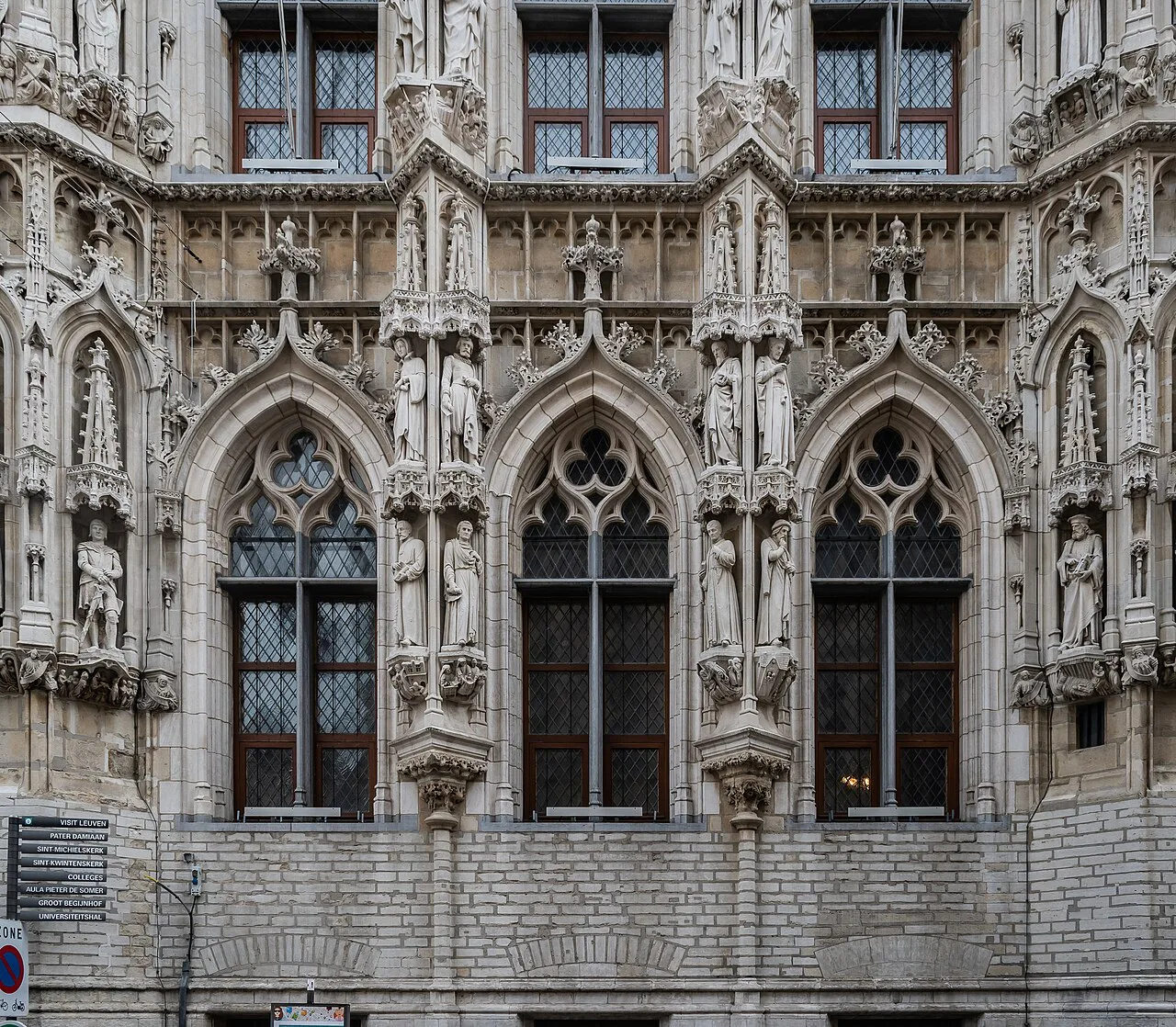 Sculpted Gothic niches and windows on the façade of Leuven Town Hall.