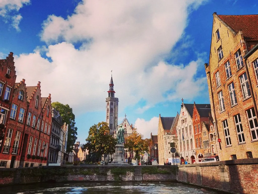 Jan van Eyck Square in Bruges, with the canal and the tower of the Poortersloge.
