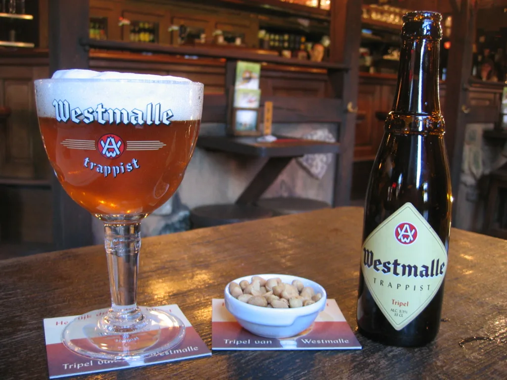 A glass and bottle of Westmalle Tripel, the abbey's pale strong beer.