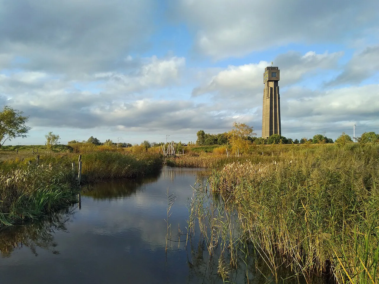The Yser Tower rising beyond the reed-fringed ponds of the IJzerboomgaard, Diksmuide.